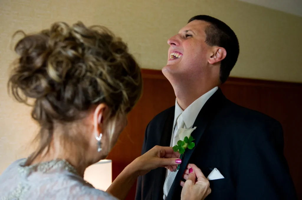 mother pinning groom boutonniere blackwell